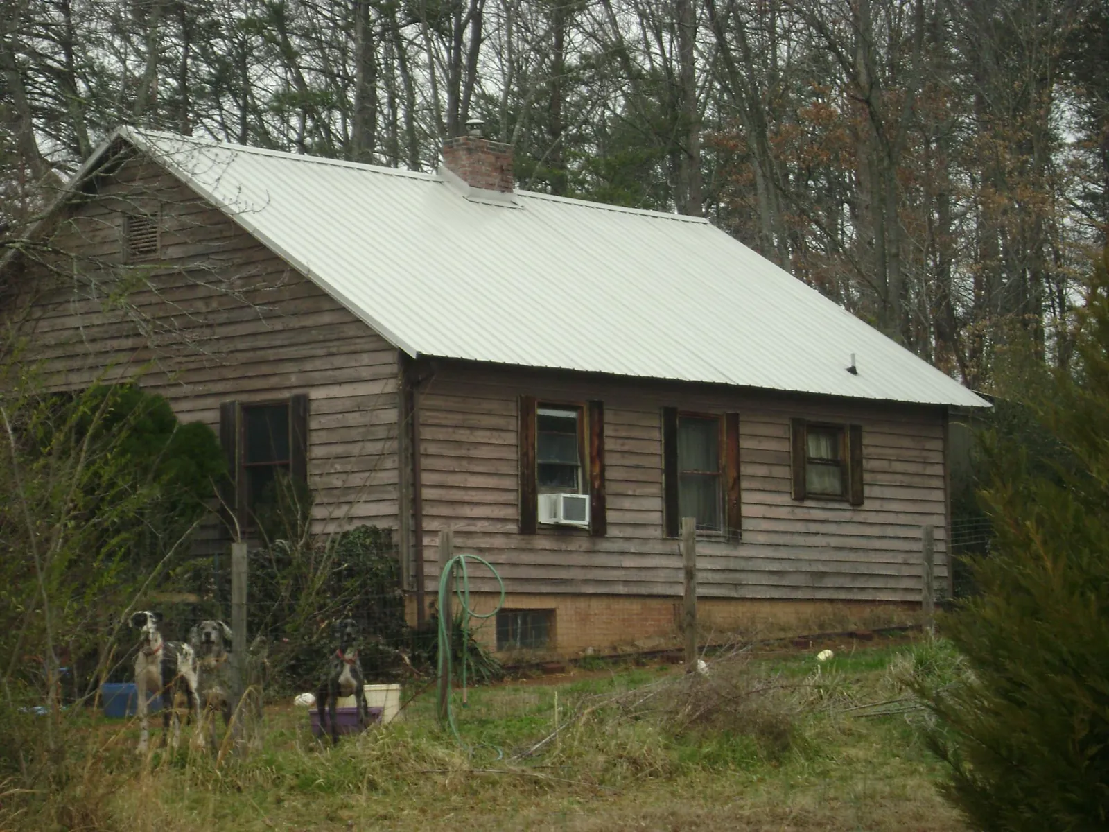 White metal roof on an old wood sided farmhouse, from a Metal Roof Installation job in Durham